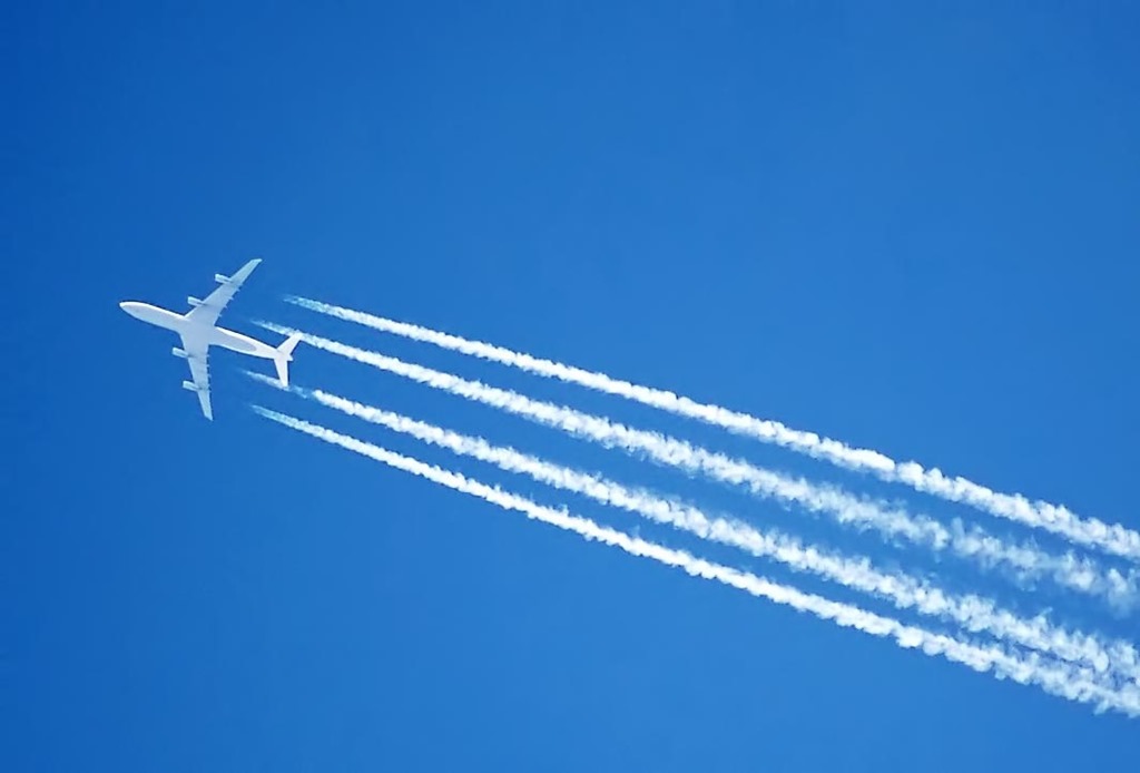 A high-flying jet's engines leaving a condensation trail (contrail)