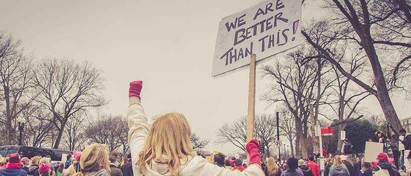 Atheists are not alt-right. Image shows a woman holding a sign - We're better than this.