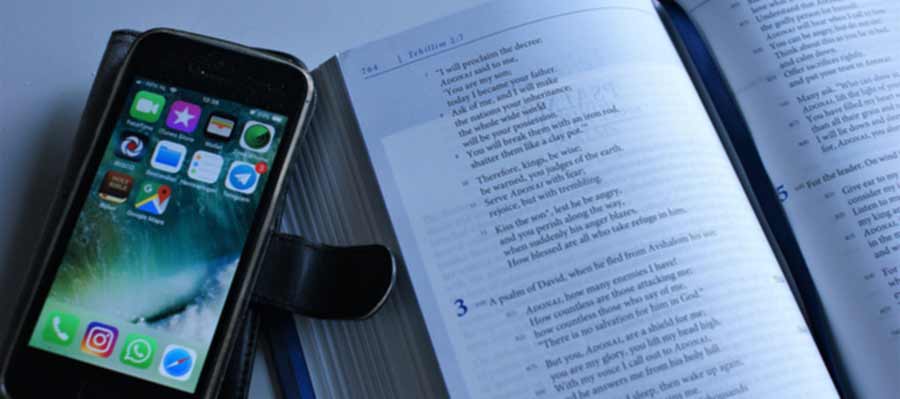 Book and phone next to it indicating distractions. The danger today, ironically, is that too much information could lead to decision fatigue and subsequently, to a person avoiding deciding and falling back to what their parents or the proverbial village preacher taught them.